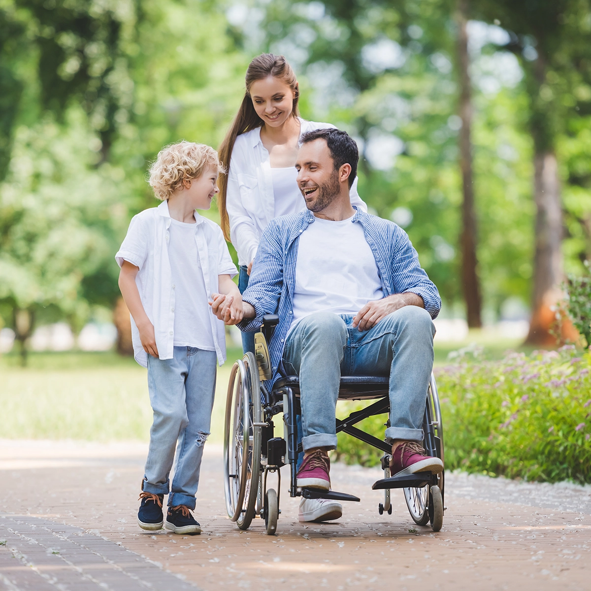man in wheelchair with family outdoors